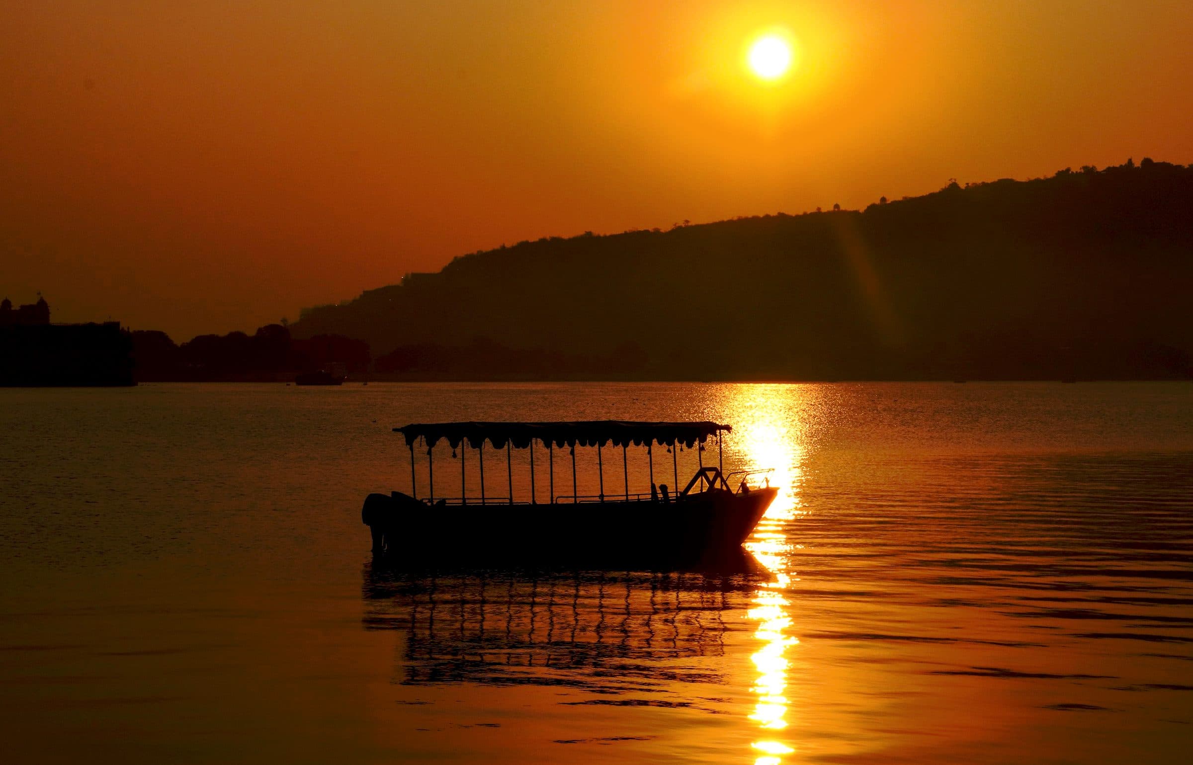 A boat on the lake at Udaipur as the sun drops behind the hills