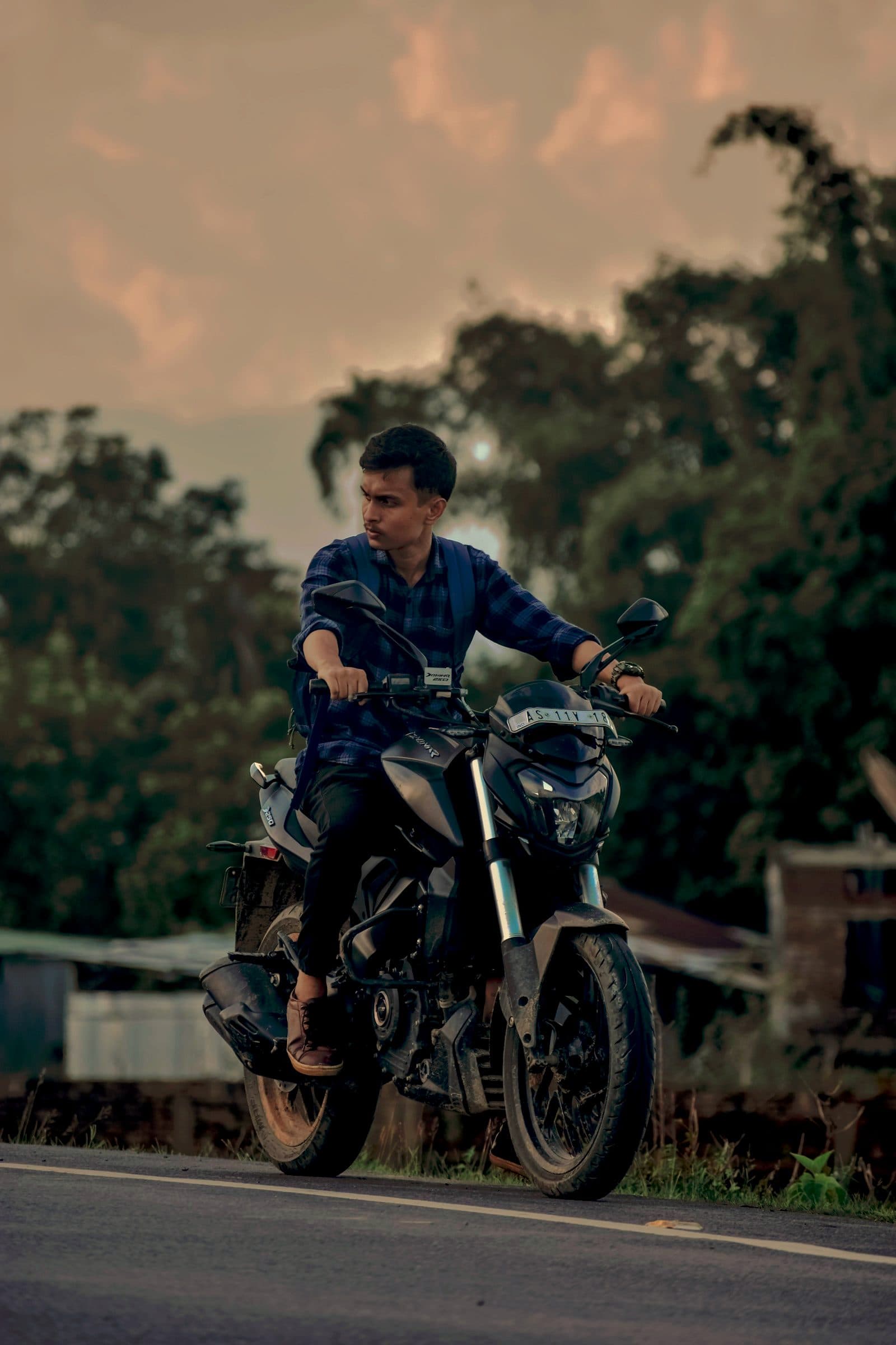 A rider easing a motorcycle along a quiet road out of town